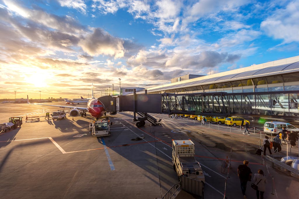 A vibrant sunset at Copenhagen Airport with airplanes and bustling activity.